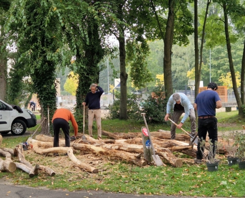 Vrijwilligers schillen hout voor de klauterbrug Vrijwilligers schillen boomstammen voor de klauterbrug